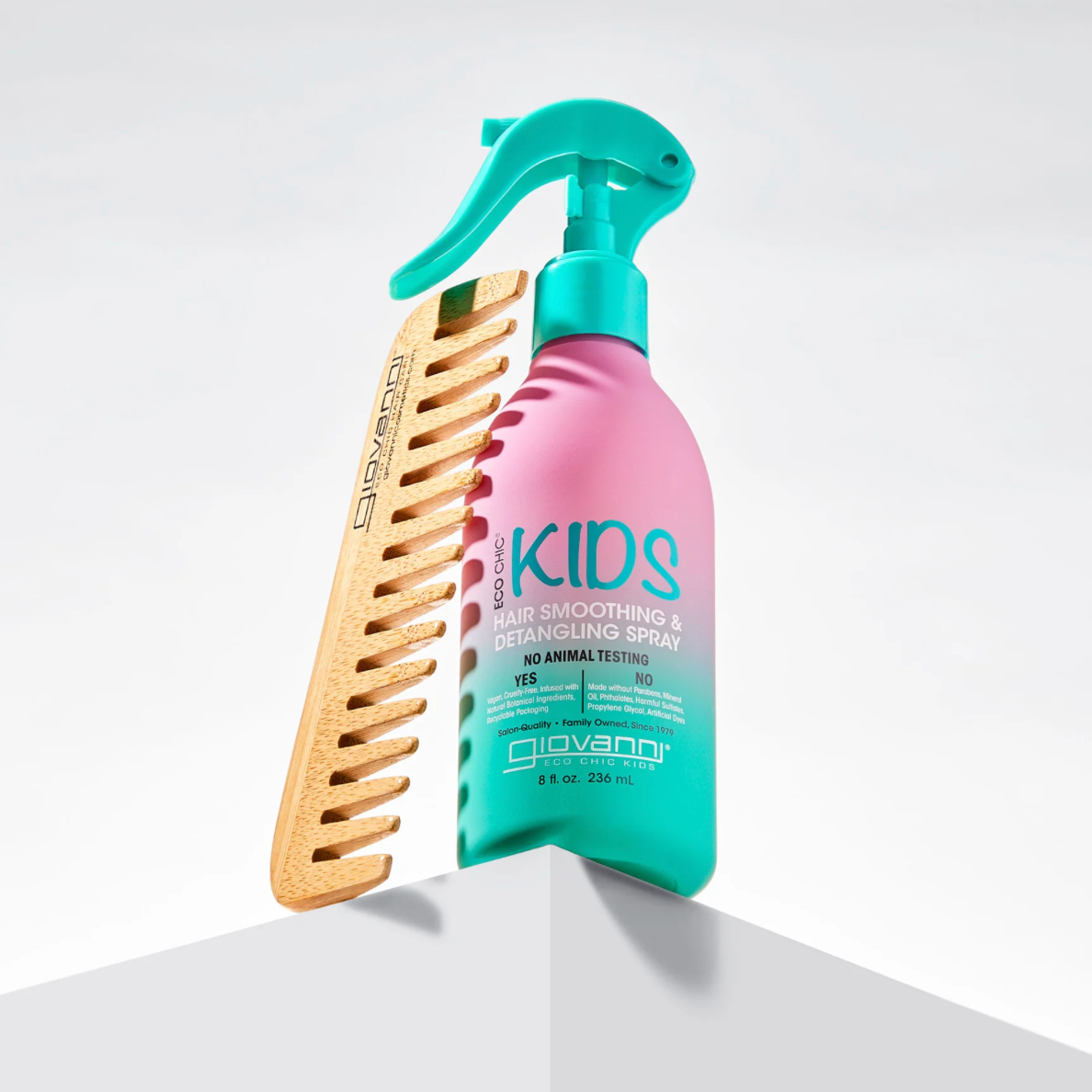 Shampoo bottle and comb on a white surface with a light gray background