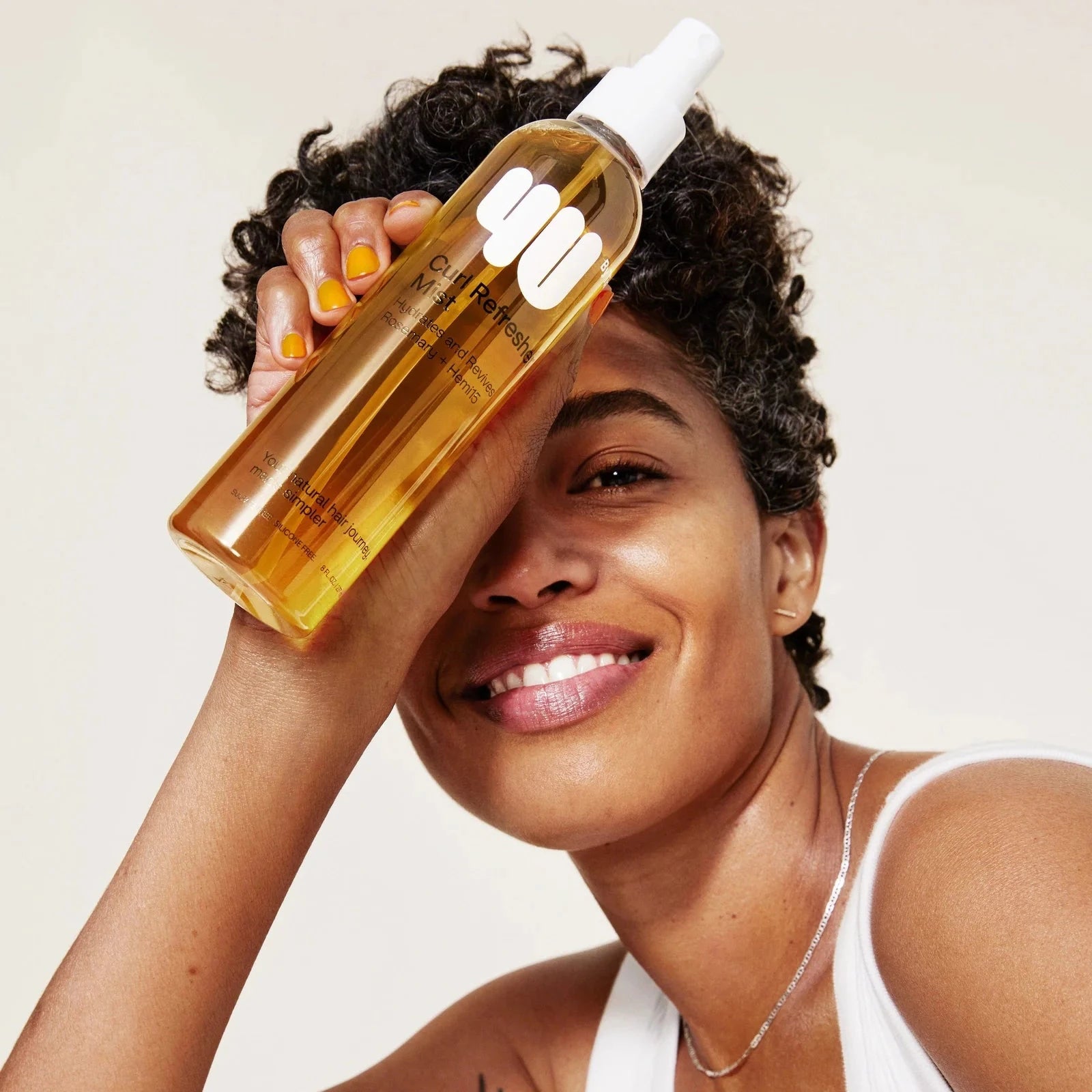 Woman holding a bottle of hair care product with a white background
