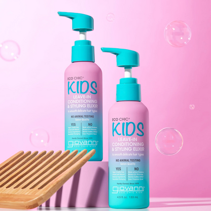Two bottles of Eco Chic Kids leave-in conditioning and styling elixir with a wooden comb on a pink background with bubbles.