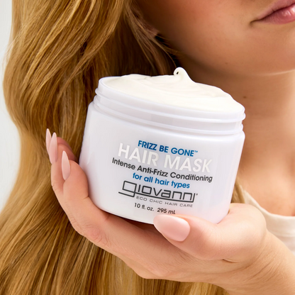 Person holding a jar of Giovanni Frizz Be Gone Hair Mask with long blonde hair.