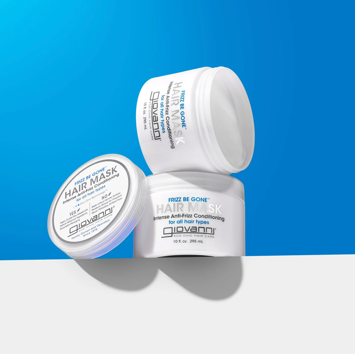 Three containers of Giovanni hair mask on a blue and white background