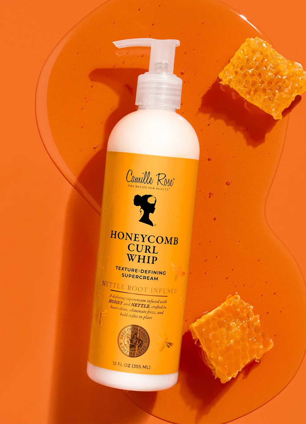 Bottle of Camille Rose Honeycomb Curl Whip on an orange background with honeycomb pieces.
