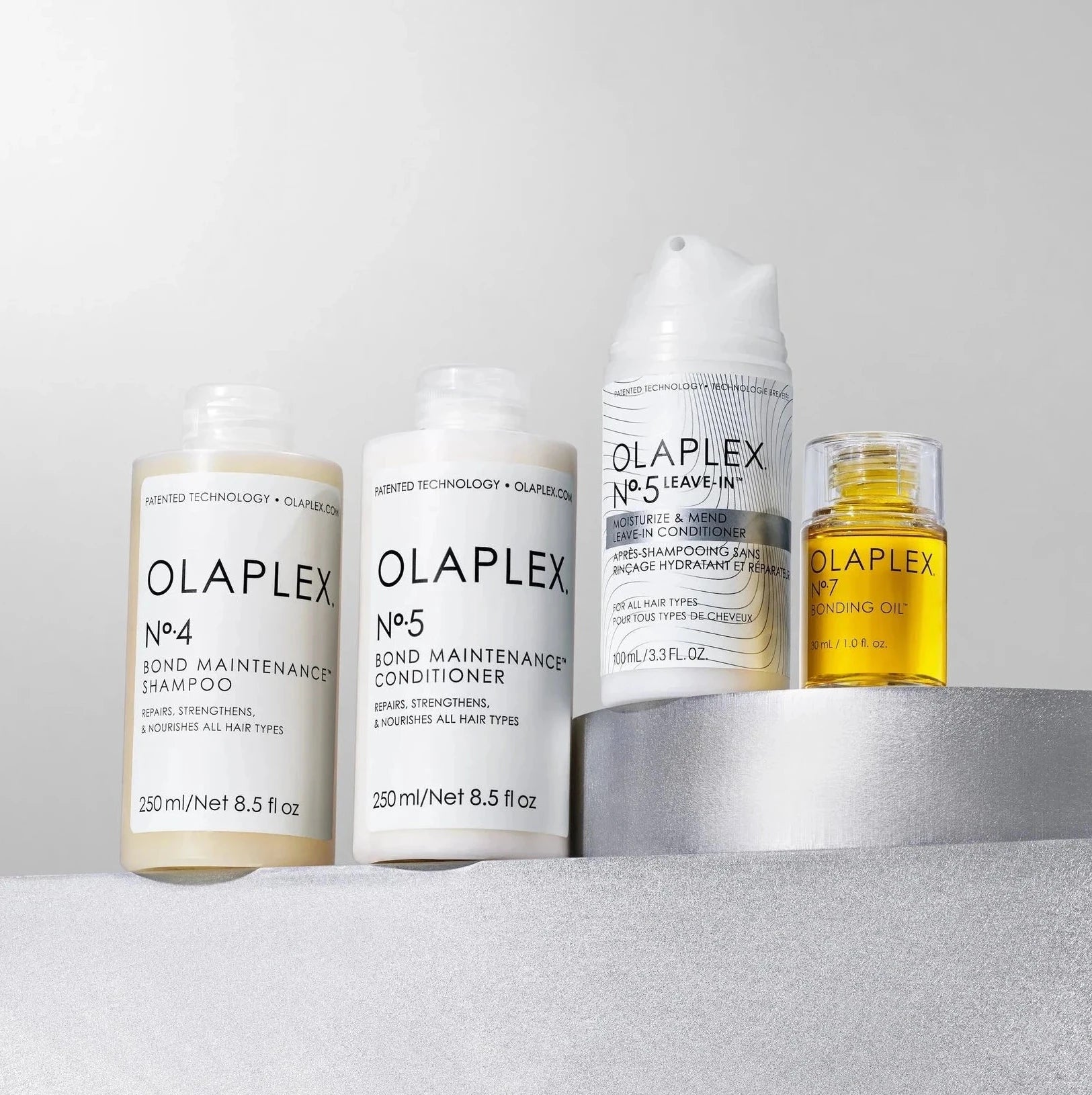 Set of Olaplex hair care products on a gray surface with a white background