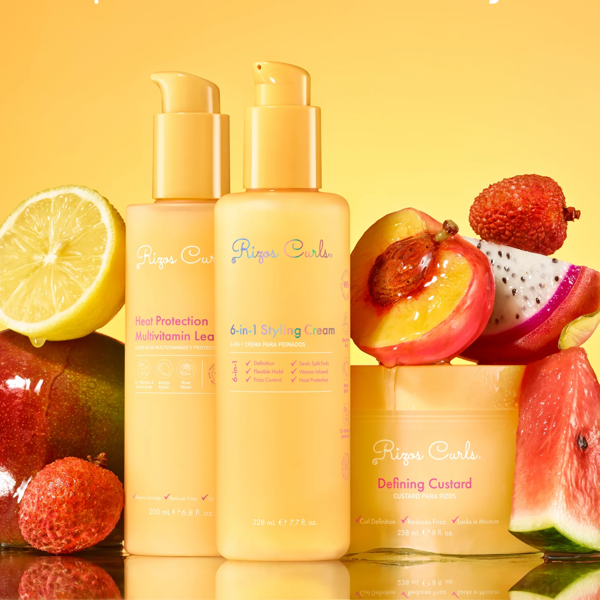 Three hair care products with fruits on a yellow background, featuring 'Rizos Curls' brand.