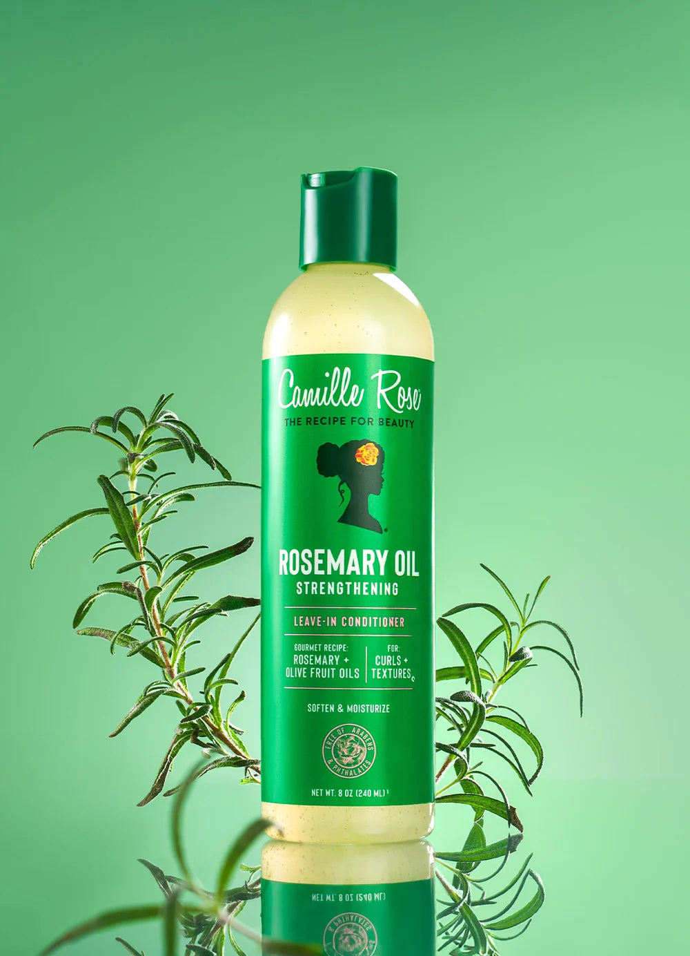 A bottle of Camille Rose Rosemary Oil Strengthening Leave-In Conditioner, featuring a green cap and a green label with white text, set against a solid green background with rosemary sprigs.