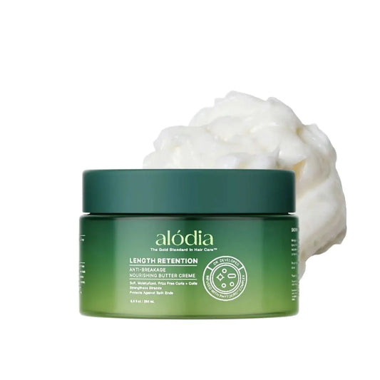 Green jar of alodia Length Retention Nourishing Butter Crème with white cream on a white background