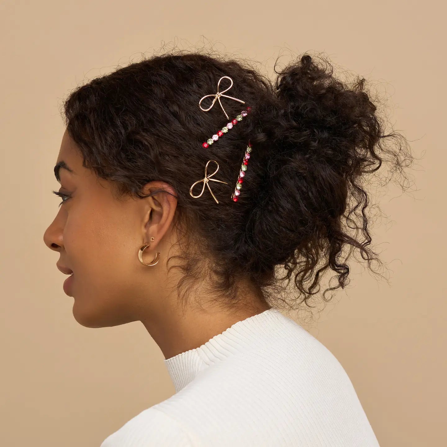Woman with styled hair featuring decorative hair pins against a beige background