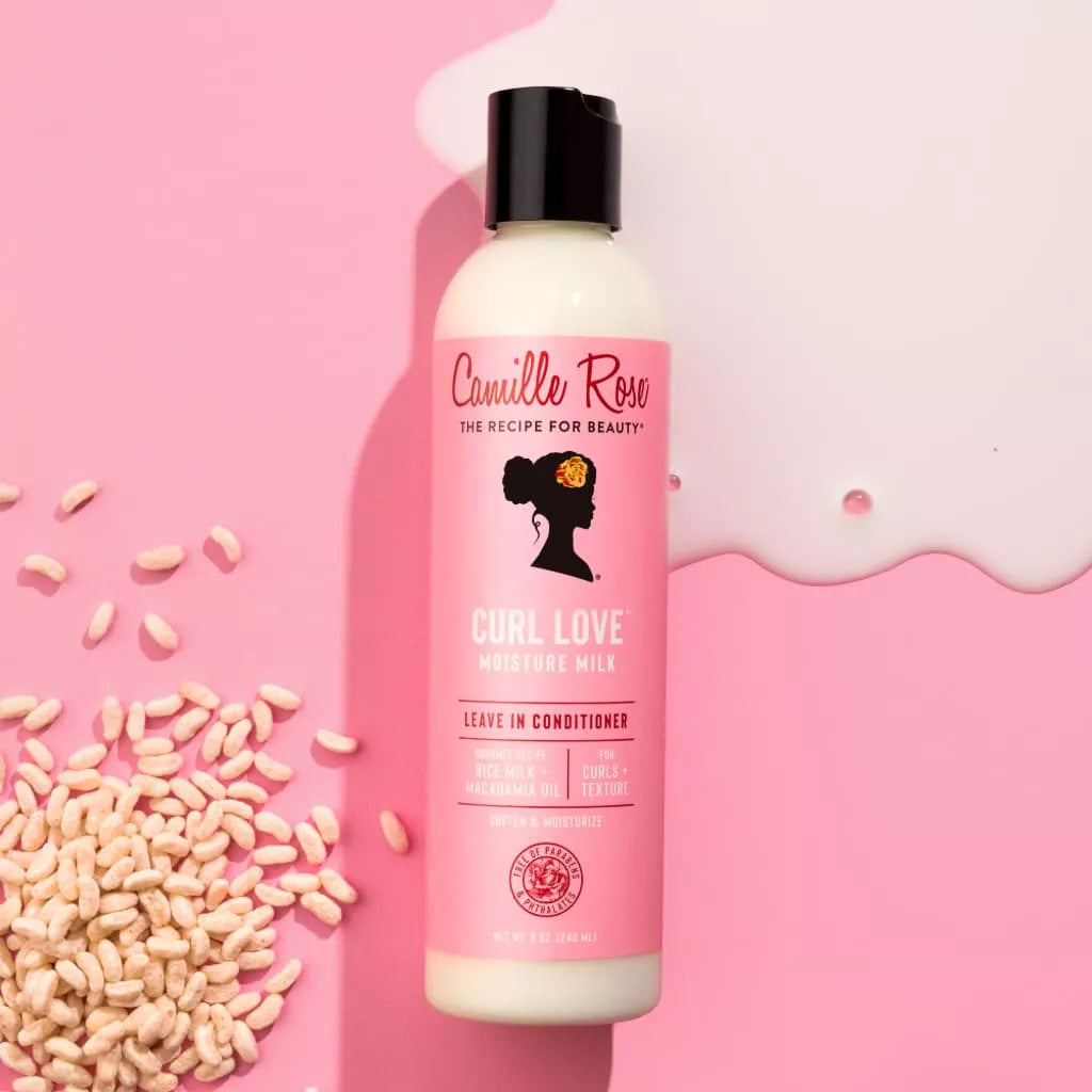 Camille Rose Curl Love Leave In Conditioner bottle on a pink background with rice kernels.